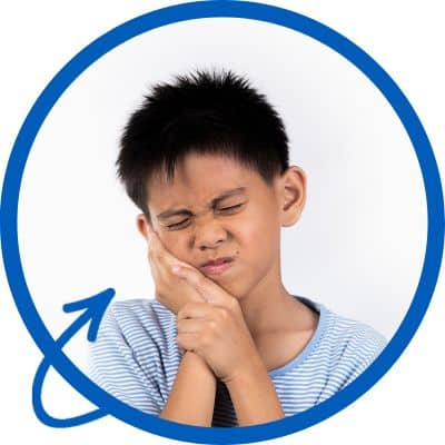 boy holding cheek in pain
