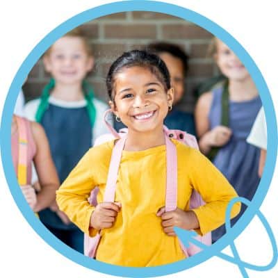 little girl wearing backpack at school
