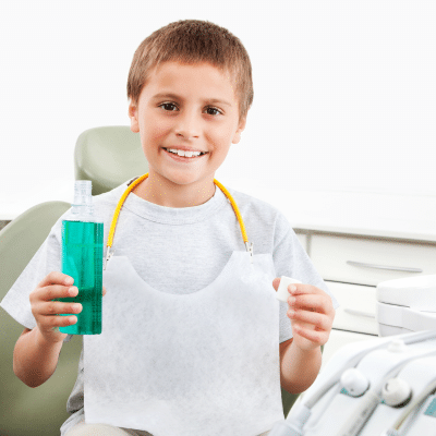 Mouthwash for Kids: When Should They Start? 4 a young boy holding a mouthwash bottle, representing mouthwash for kids