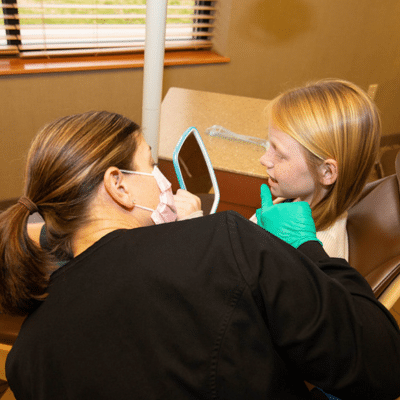 The Importance of Regular Dental Checkups for Children 2 PDOC dentist talking to a little girl, representing importance of regular dental checkups for children